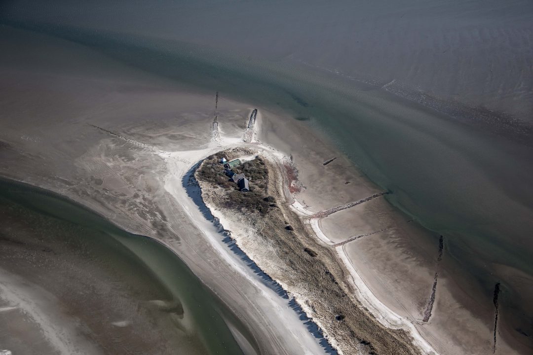 Aan het eind van de lange smalle duinenrij staat een uitkijktoren, een romneyloods en nog wat andere onderkomens